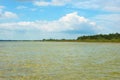 Black Sea foreland landscape. Green water surface, forest on horizont line and blue sky with clouds. Royalty Free Stock Photo