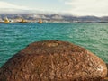 Black sea, Novorossiysk. Sea transport, boats, barges and cranes. Windy weather. Clouds roll over the mountain range.