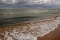 Black Sea. Water with waves. Dark cloudy weather. Deep bright blue water. Before storm. Sand coast Royalty Free Stock Photo