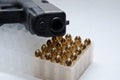 A black semiautomatic 9mm pistol laying on top of a plastic bullet case Royalty Free Stock Photo