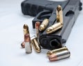 A black semiautomatic 9mm pistol with ten bullets on and around it Royalty Free Stock Photo