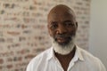 Black senior man smiling and standing at home