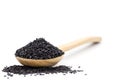 Black sesame seed in wooden spoon and piles sesame seeds on white background Royalty Free Stock Photo