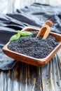 Black sesame seeds in a wooden bowl.