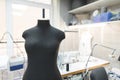 Black sewing mannequin on a background of workplace seamstresses. Sewing concept