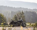 Black shiny high-speed motorcycle parked on empty narrow country roadside on sunny summer day. Royalty Free Stock Photo