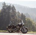 Black shiny high-speed motorcycle parked on empty narrow country roadside on sunny summer day. Royalty Free Stock Photo