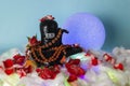 Black Shivalingam figure in Divali lights with rudraksha beads and roses.