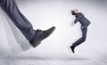 Black shoe kicking small man Royalty Free Stock Photo