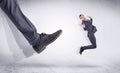 Black shoe kicking small man Royalty Free Stock Photo