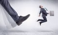 Black shoe kicking small man Royalty Free Stock Photo