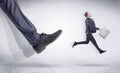 Black shoe kicking small man Royalty Free Stock Photo