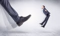 Black shoe kicking small man Royalty Free Stock Photo