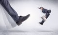 Black shoe kicking small man Royalty Free Stock Photo