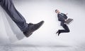 Black shoe kicking small man Royalty Free Stock Photo