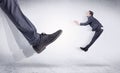 Black shoe kicking small man Royalty Free Stock Photo