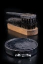 Black shoe polish, brush and shoes on the table. Accessories for cleaning leather footwear Royalty Free Stock Photo