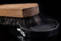 Black shoe polish, brush and shoes on the table. Accessories for cleaning leather footwear Royalty Free Stock Photo