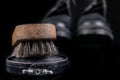 Black shoe polish, brush and shoes on the table. Accessories for cleaning leather footwear