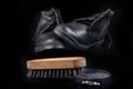 Black shoe polish, brush and shoes on the table. Accessories for cleaning leather footwear Royalty Free Stock Photo