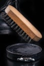 Black shoe polish, brush and shoes on the table. Accessories for cleaning leather footwear Royalty Free Stock Photo