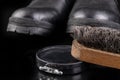 Black shoe polish, brush and shoes on the table. Accessories for cleaning leather footwear Royalty Free Stock Photo