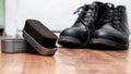 Black shoe polish brushes and shoes on wooden floor Royalty Free Stock Photo