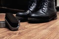 Black shoe polish brushes and shoes on wooden floor Royalty Free Stock Photo