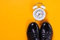 Black shoes and alarm clock on colored background. Flat lay, top view. Fashion blog look Royalty Free Stock Photo