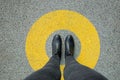 Black shoes standing in yellow circle on the asphalt concrete floor. Comfort zone or frame concept. Feet standing inside comfort Royalty Free Stock Photo