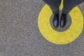 Black shoes standing in yellow circle on the asphalt concrete floor. Comfort zone or frame concept. Feet standing inside comfort Royalty Free Stock Photo