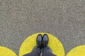 Black shoes standing in yellow circle on the asphalt concrete floor. Comfort zone or frame concept. Feet standing inside comfort Royalty Free Stock Photo