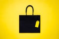Black shopping paper bag with blank yellow price tag Royalty Free Stock Photo