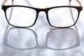 Black shortsighted or nearsighted eyeglasses on white acrylic table background, Close up & Macro shot, Reflection, Optical concept