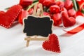 A black sign against a background of red tulips on white table. The concept of Mother`s Day. Copy space Royalty Free Stock Photo