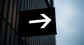 Black sign with glowing white arrow on textured wall points right Royalty Free Stock Photo