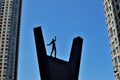 The black silhouette of an acrobat balancing on a pedestal