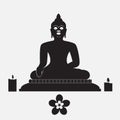 Black silhouette of Buddha with candle and flower