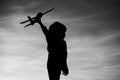 Black silhouette of cute happy child running at countryside and holding toy plane in hand. Happy childhood. Summer Royalty Free Stock Photo
