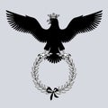 Black silhouette of an eagle in crown with outstretched wings holding a laurel branch Royalty Free Stock Photo