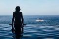 Woman at infinity swimming pool with sea view Royalty Free Stock Photo