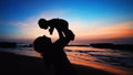 Black silhouette of mother, baby son walking by sea beach Royalty Free Stock Photo