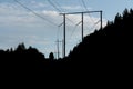 Black silhouette of power lines against a blue sky with white clouds Royalty Free Stock Photo