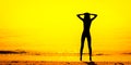 Black silhouette of slim girl on the sea beach, hands by head, yellow tone Royalty Free Stock Photo