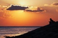 Black silhouette of thinking man sitting alone on sea beach Royalty Free Stock Photo