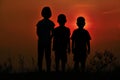 Black silhouette of three children standing together. There is a sky at sunset Royalty Free Stock Photo