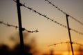 Black silhouette of a torn barbed wire fence at sunset Royalty Free Stock Photo