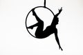 Black silhouette of a young woman posing on an air ring on an isolated white studio background. Female aerial acrobat Royalty Free Stock Photo