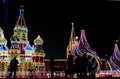 Black silhouettes of people amid the bright lights of Christmas street scenery. Night shooting of urban landscape