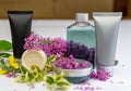 Black, silver tube, clear water bottle, creame box and soap with flower on white desk. Product placement background